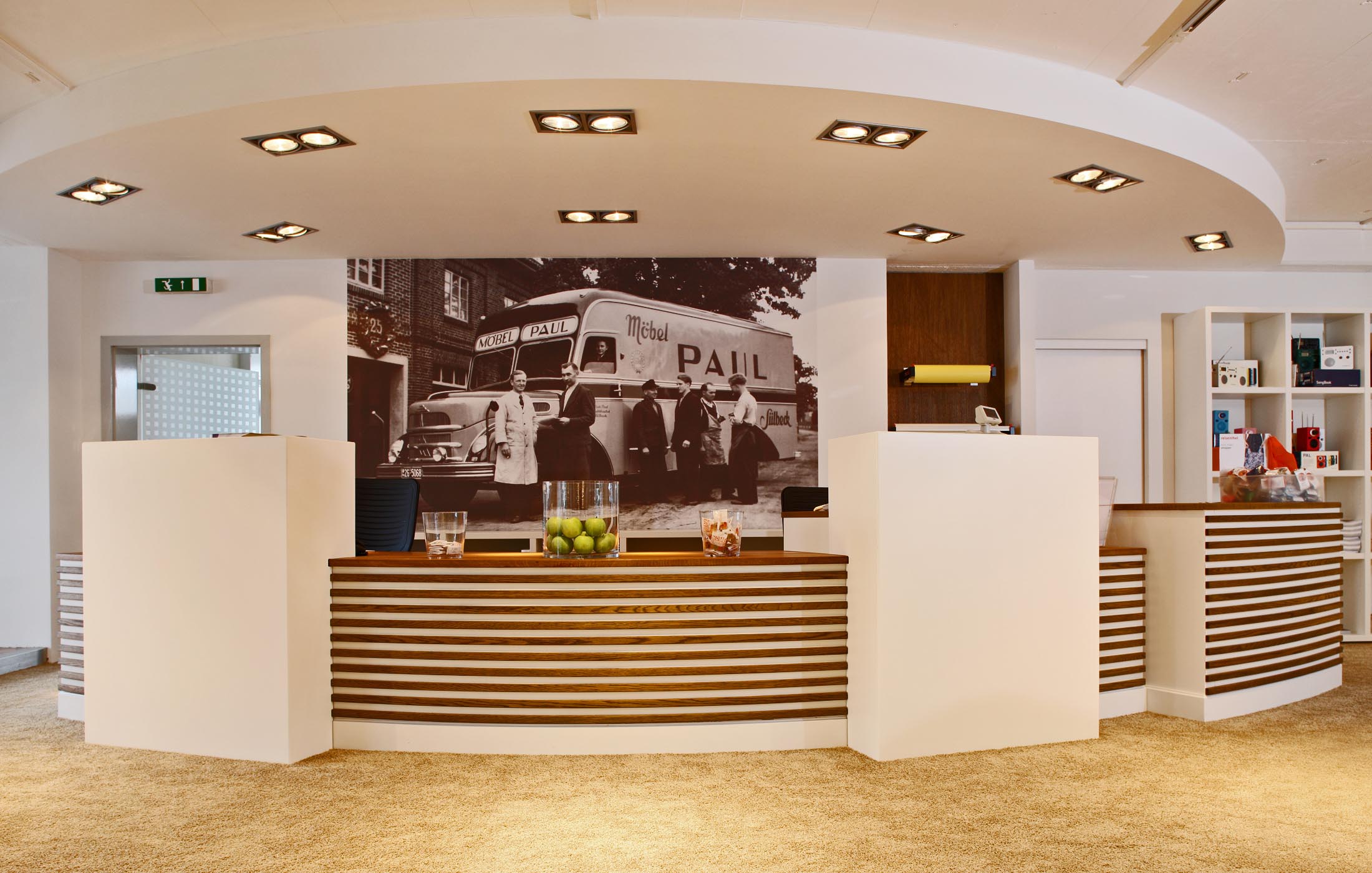 Empfangstresen mit historischem Schwarz-Weiß-Foto im Hintergrund und moderner Beleuchtung.
