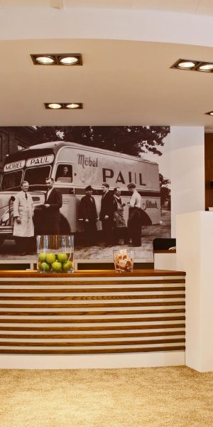 Empfangstresen mit historischem Schwarz-Weiß-Foto im Hintergrund und moderner Beleuchtung.