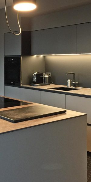 Moderne Einbauküche mit Kücheninsel, Hängelampen und klaren Linien.