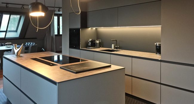 Moderne Einbauküche mit Kücheninsel, Hängelampen und klaren Linien.